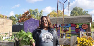 A woman stands in front of a garden in Columbus.