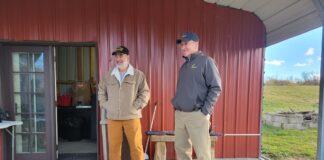 two men standing together in front of a farm store