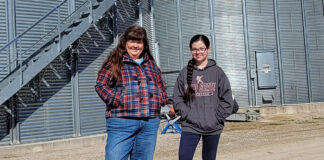 Marcia and Mae Ruff stand in front of grain containers, Feb. 11. The containers were built in partnership with Farmers Business Network.