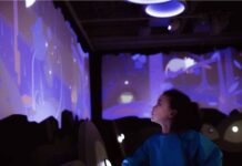 Full STEAM ahead: First children’s museum to open in Mid-Ohio Valley in April child looks at a blue interactive wall reflecting a water table