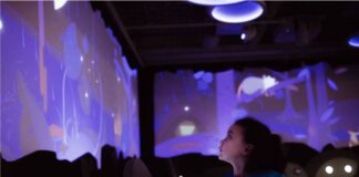 Full STEAM ahead: First children’s museum to open in Mid-Ohio Valley in April child looks at a blue interactive wall reflecting a water table