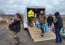 Donations arrive from Indianapolis for farmers, pet owners affected by train derailment people carry donated items out of a trailer
