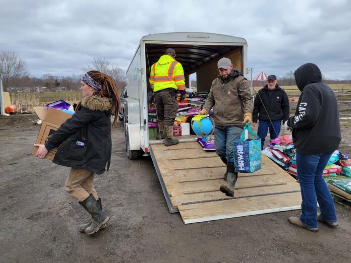 indianapolis-donations-3 people carry donated items out of a trailer
