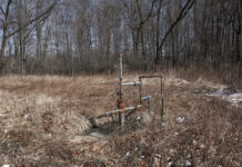 Penn State offers landowners $100 per undocumented well A well head sits in a brushy area next to some trees