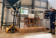 Growing demand in Ohio for culinary chestnuts fuels renewed interest in North American tree woman stands beside chestnut milling machine at Rural Action