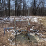 Failure by design: Leaking oil and gas wells slip through the cracks a well head sits in a brushy area next to some trees