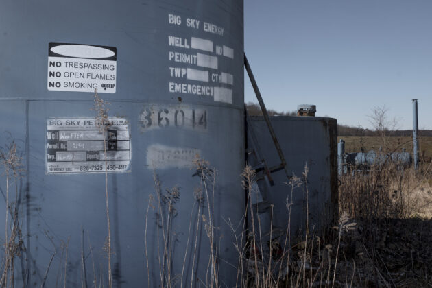 a blue metal storage tank is highlight in the foreground of the photo