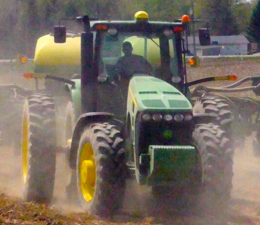 Trump administration comes to aid of farmers with $12 billion in payments tractor plowing field kicking up dust