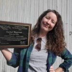 Farm and Dairy reporter wins international writing award a woman stands holding an awards plaque