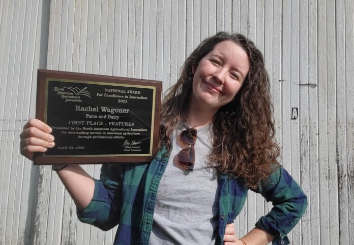 rachel with award a woman stands holding an awards plaque
