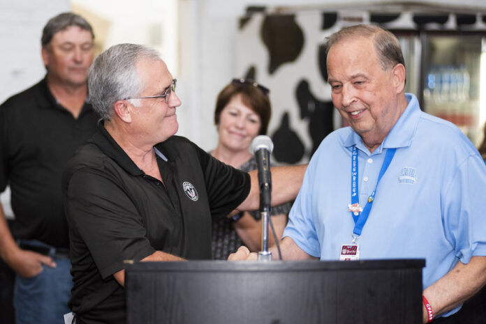 Virgil Strickler Ohio State Fair manager two white men shake hands behind a lecturn