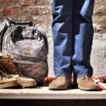 Proud veteran minimalist photography of person standing near backpack and boots