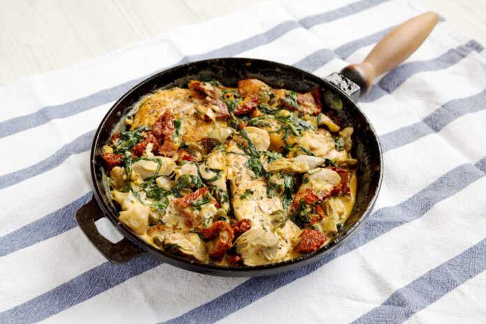Homemade Creamy Tuscan Chicken in a cast-iron pan, side view. Marry Me Chicken