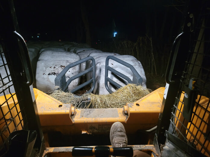 rachel wagoner column the view from the seat of a skid steer, looking out onto a sea of large round hay bales wrapped in white plastic