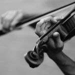 grayscale photo of person playing violin