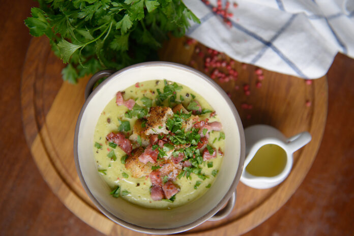 A lovely soup with croutons and ham on the table - top view