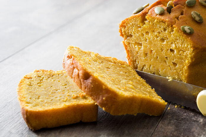 Homemade pumpkin bread on wooden table.