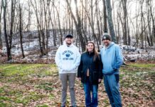 Tannar, Kimberly and Tom Barton stand in their backyard in Alicia, Pennsylvania on Dec. 7, 2025. The former Robena Coal Mine site is further up the hill.