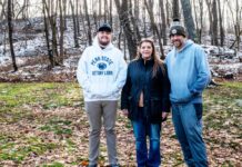 Tannar, Kimberly and Tom Barton stand in their backyard in Alicia, Pennsylvania on Dec. 7, 2025. The former Robena Coal Mine site is further up the hill.